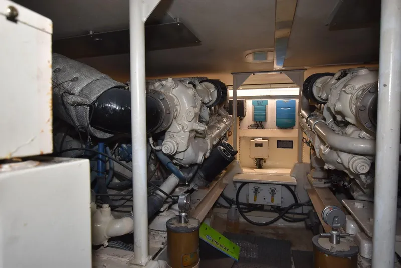 Slide: The Image of Engine room of a 1997 Viking 50 Convertible yacht, showcasing dual engines and mechanical components. - 27