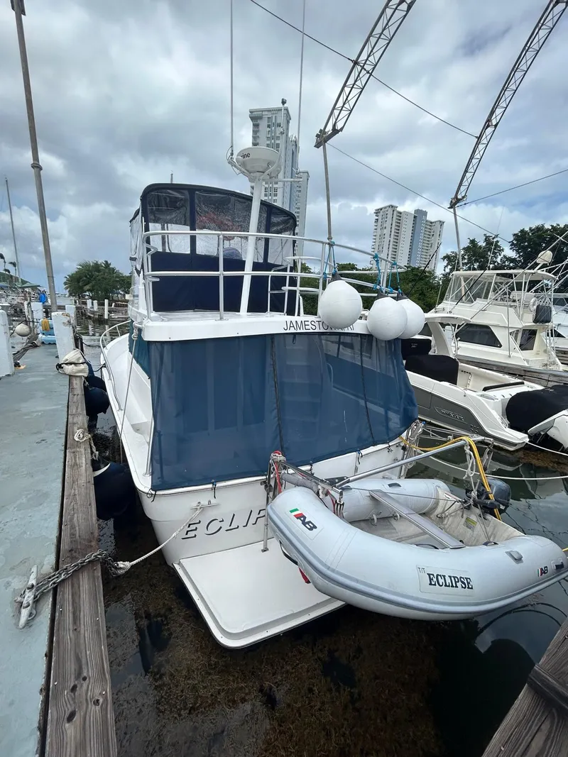 Slide: The Image of 1999 Mainship 350 Trawler docked with inflatable boat, marina background. - 11