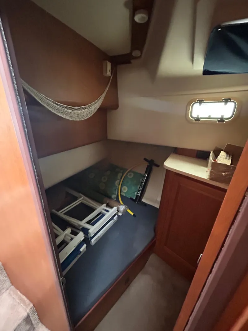 Slide: The Image of 1999 Mainship 350 Trawler cabin interior with hammock and storage space. - 7