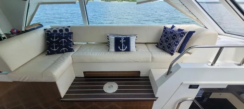 Slide: The Image of Luxurious 2011 Cruisers Yachts 48 Cantius interior with nautical-themed cushions and scenic water view. - 2