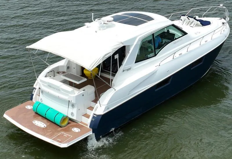 Slide: The Image of 2011 Cruisers Yachts 48 Cantius on water, featuring sleek design and spacious deck. - 34