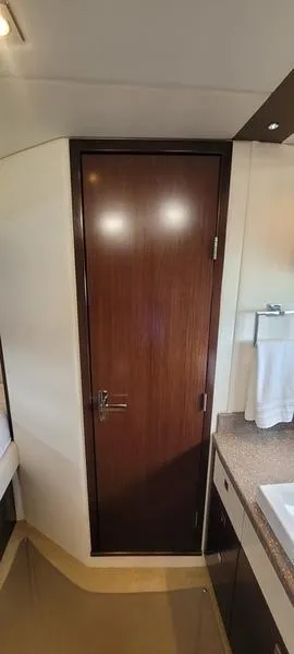 Slide: The Image of Interior of 2011 Cruisers Yachts 48 Cantius, featuring a wooden door and modern bathroom. - 36