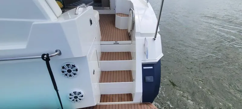 Slide: The Image of 2011 Cruisers Yachts 48 Cantius, rear deck view with wooden steps and water backdrop. - 42