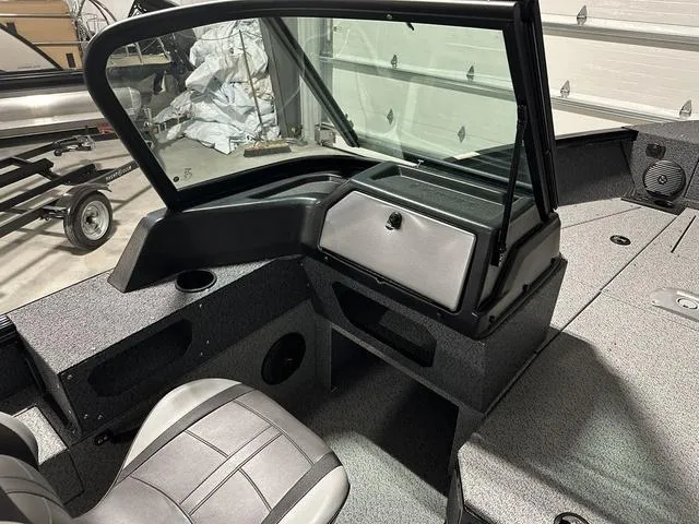 Slide: The Image of 2025 Lund 1775 Impact XS Sport boat interior with seating and storage compartments. - 12