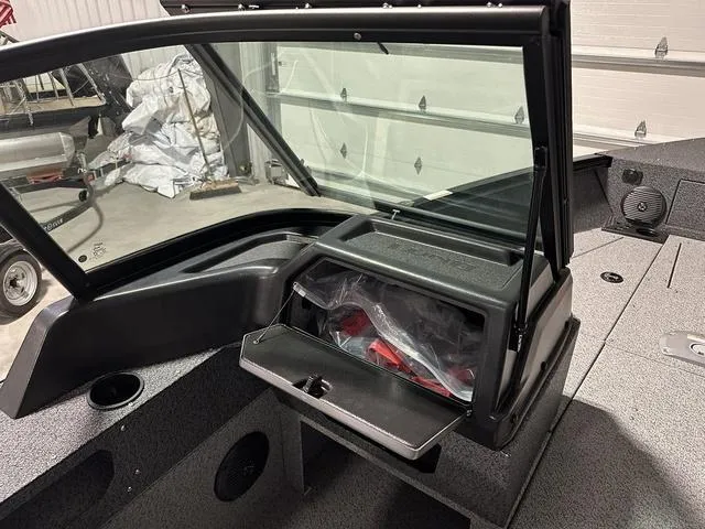 Slide: The Image of 2025 Lund 1775 Impact XS Sport boat interior with open storage compartment. - 13