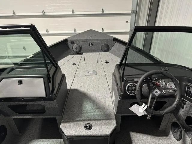 Slide: The Image of 2025 Lund 1775 Impact XS Sport boat interior with steering wheel and dashboard. - 14