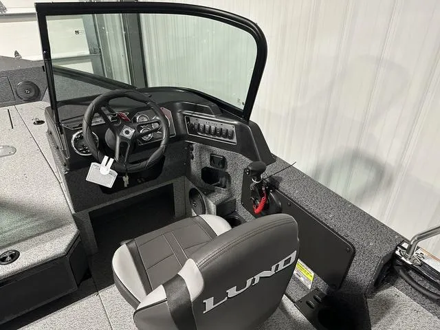 Slide: The Image of 2025 Lund 1775 Impact XS Sport boat interior with steering wheel and seat. - 16