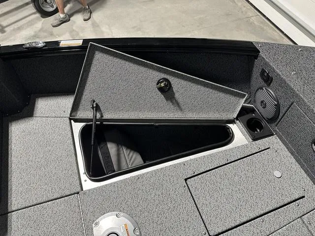 Slide: The Image of 2025 Lund 1775 Impact XS Sport boat storage compartment, open lid, gray interior. - 21