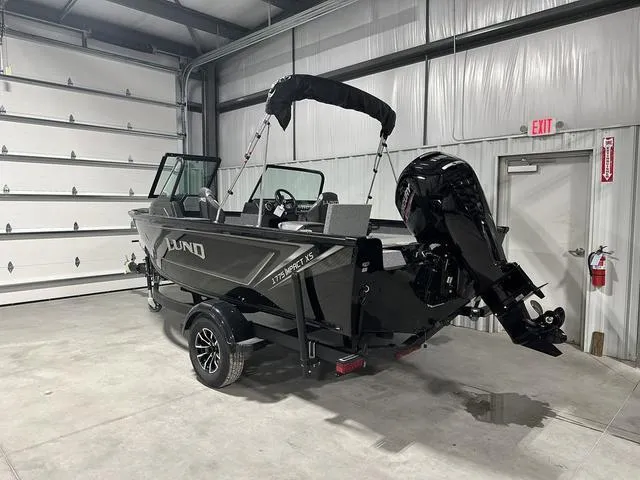 Slide: The Image of 2025 Lund 1775 Impact XS Sport boat in a garage, featuring sleek design and powerful motor. - 3