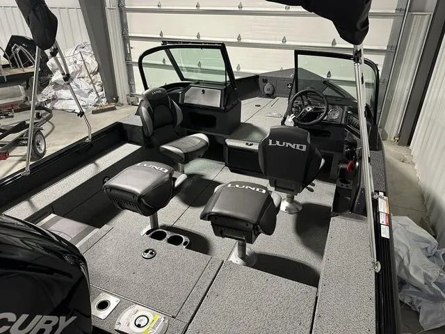 Slide: The Image of 2025 Lund 1775 Impact XS Sport boat interior with seating and steering console. - 5