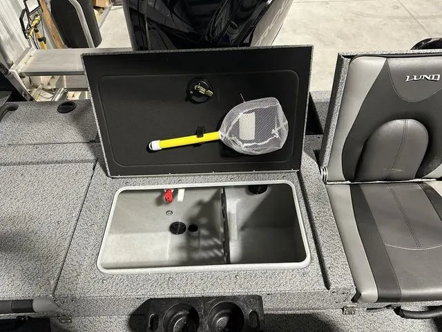 Slide: The Image of 2025 Lund 1775 Impact XS Sport boat interior with storage compartment and fishing net. - 7