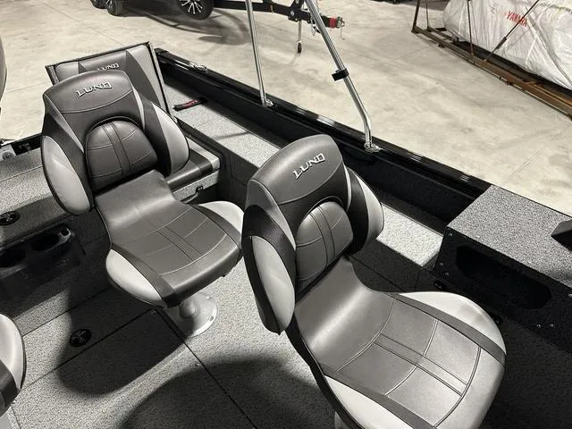 Slide: The Image of 2025 Lund 1775 Impact XS Sport boat interior with two black and gray seats. - 9