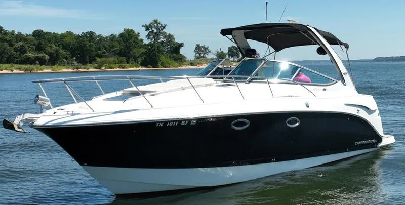 The Image of 2009 Chaparral 310 Signature boat on calm water, near a wooded shoreline. - 0