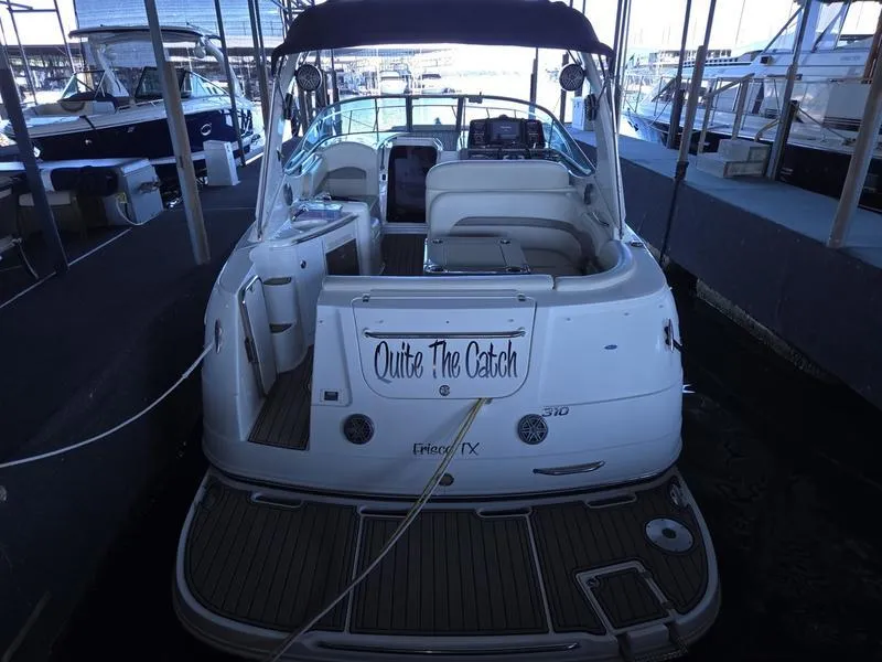 Slide: The Image of 2009 Chaparral 310 Signature boat docked, rear view, with "Quite The Catch" sign. - 2