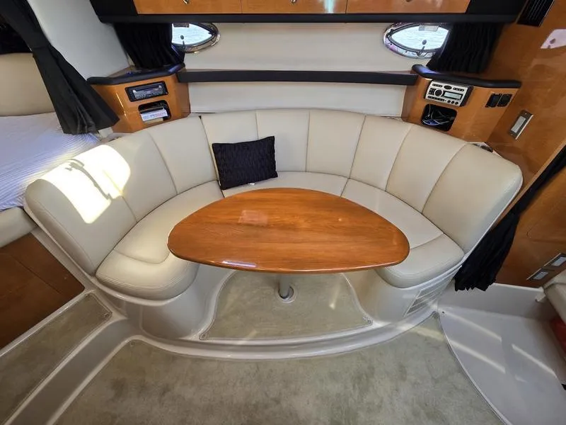 Slide: The Image of 2009 Chaparral 310 Signature yacht interior with curved seating and wooden table. - 21