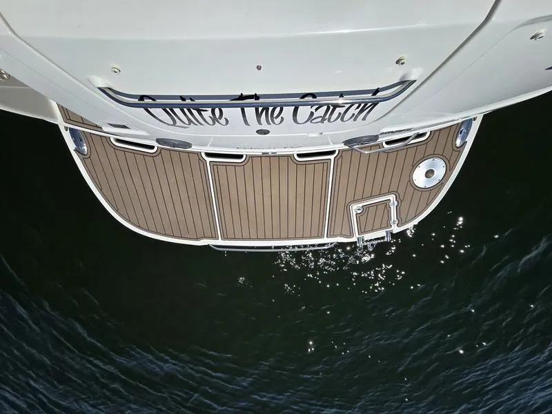 Slide: The Image of Chaparral 310 Signature 2009 boat stern view with wooden deck over water. - 26