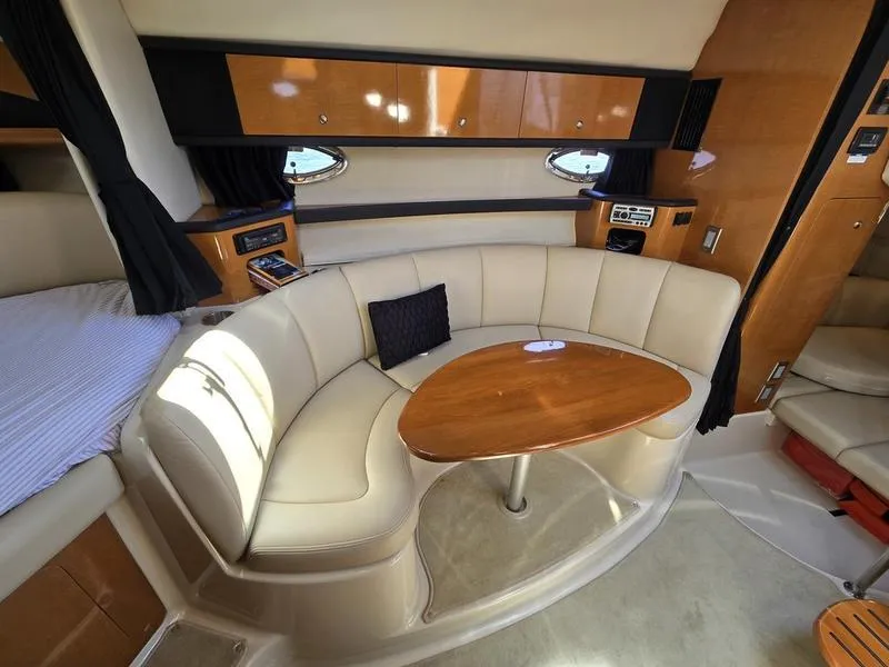 Slide: The Image of 2009 Chaparral 310 Signature yacht interior with curved seating and wooden table. - 8
