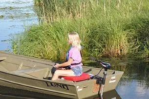 Slide: The Image of 2024 Lund 1448 Jon Tiller boat on a calm lake with lush greenery. - 5