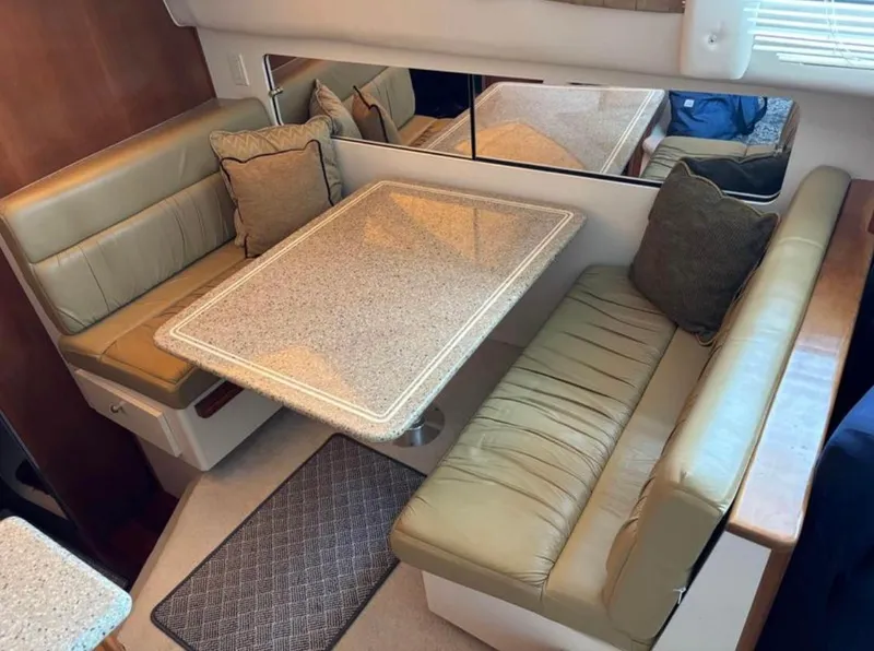 Slide: The Image of Interior of 2001 Carver 356 Motor Yacht with cozy dining area and cushioned seating. - 19