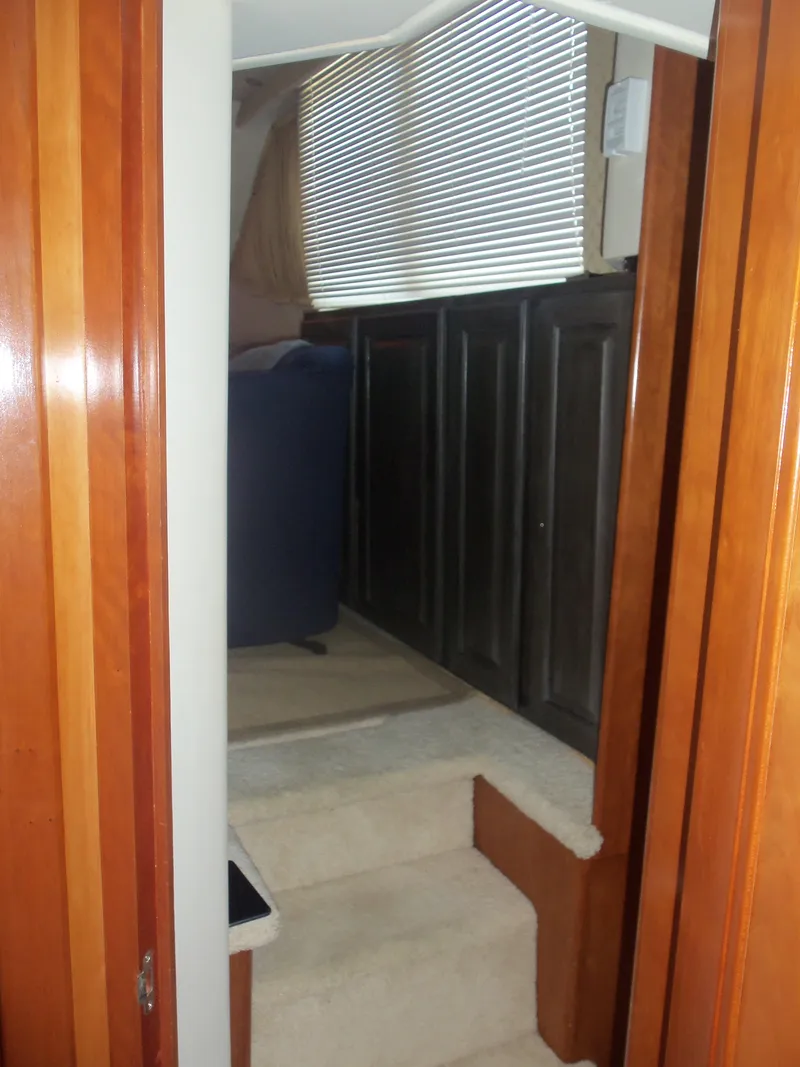 Slide: The Image of Interior view of 2001 Carver 356 Motor Yacht with wooden finishes and carpeted steps. - 26