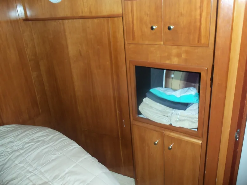 Slide: The Image of Wooden interior of 2001 Carver 356 Motor Yacht with storage cabinets and bedding. - 27