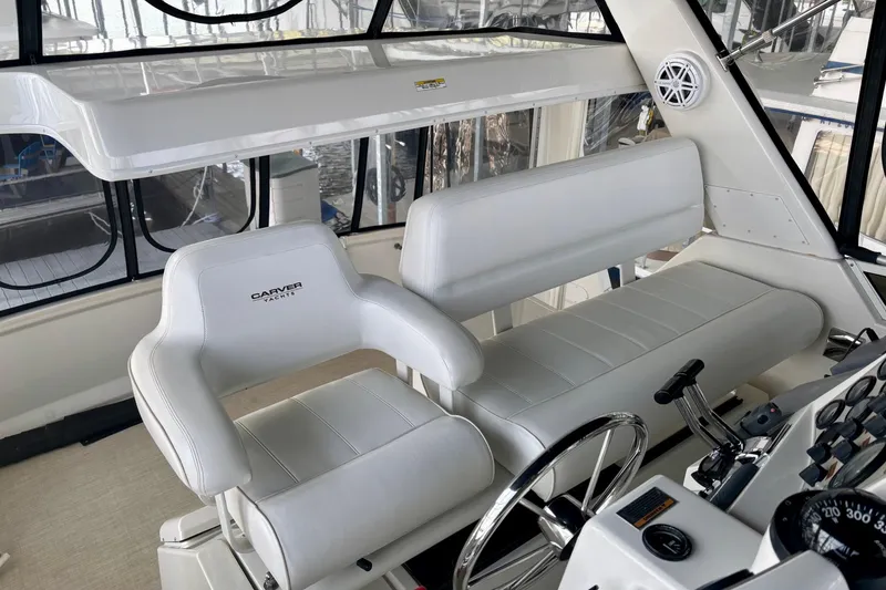 Slide: The Image of Interior helm of 2001 Carver 356 Motor Yacht with white seating and control panel. - 38