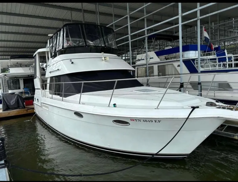 Slide: The Image of 2001 Carver 356 Motor Yacht docked in a marina under a covered structure. - 4