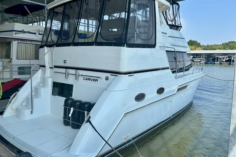 Slide: The Image of 2001 Carver 356 Motor Yacht docked at marina, featuring sleek design and spacious deck. - 43