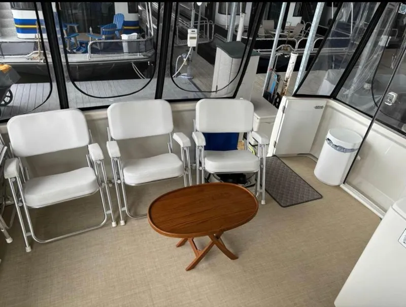 Slide: The Image of Interior of 2001 Carver 356 Motor Yacht with white chairs and wooden table. - 6