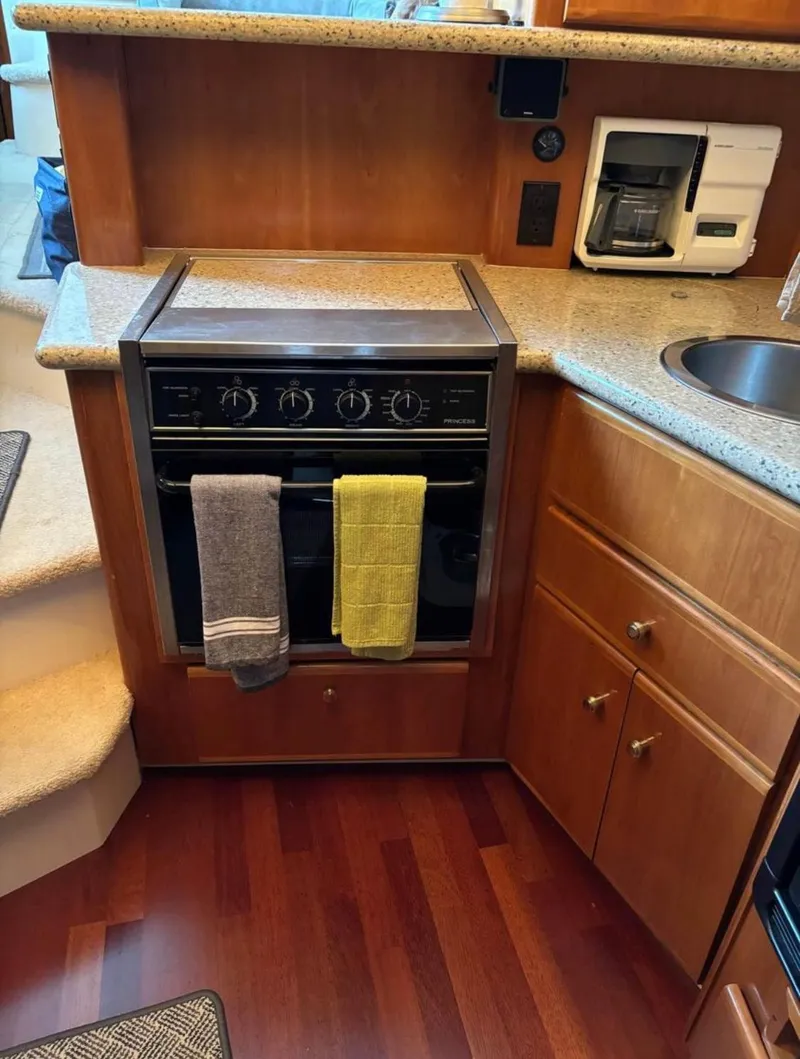 Slide: The Image of 2001 Carver 356 Motor Yacht kitchen with stove, coffee maker, and wooden cabinetry. - 18