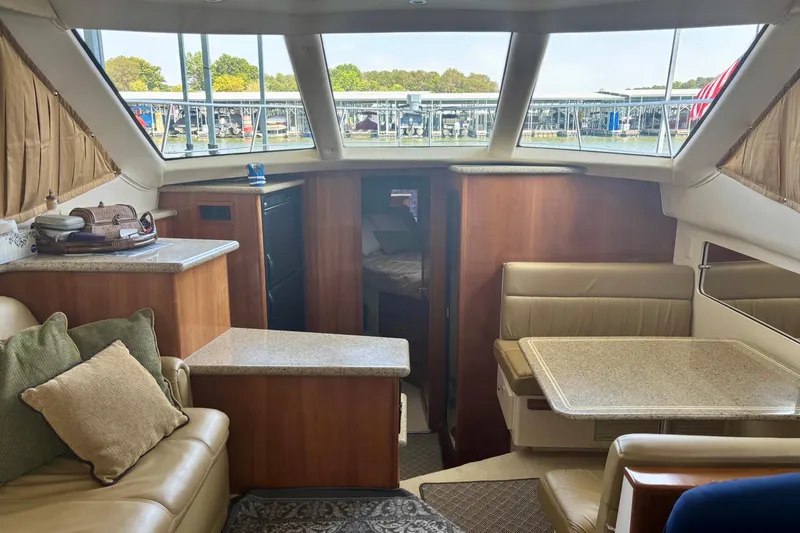 Slide: The Image of Interior of 2001 Carver 356 Motor Yacht with seating, table, and windows overlooking marina. - 42