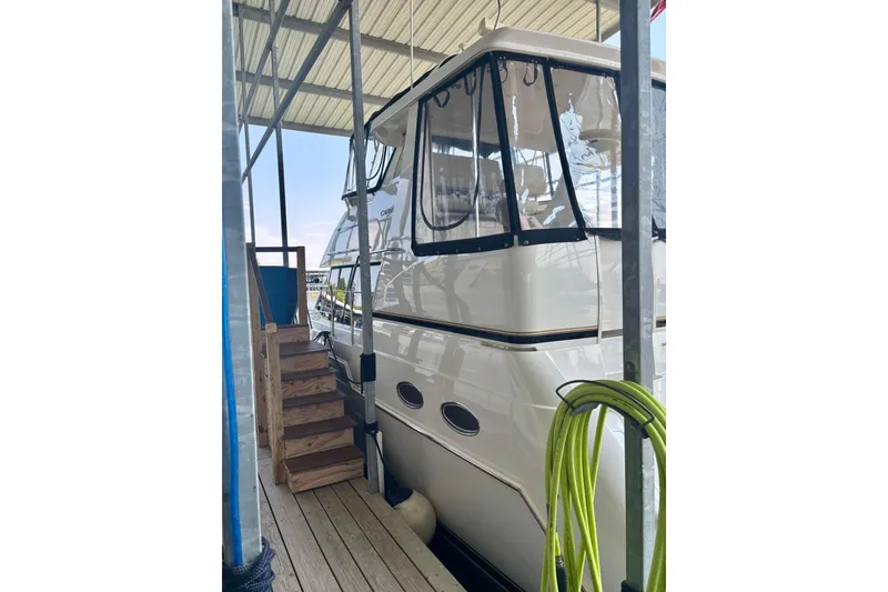 Slide: The Image of 2001 Carver 356 Motor Yacht docked under a covered marina with wooden steps. - 46