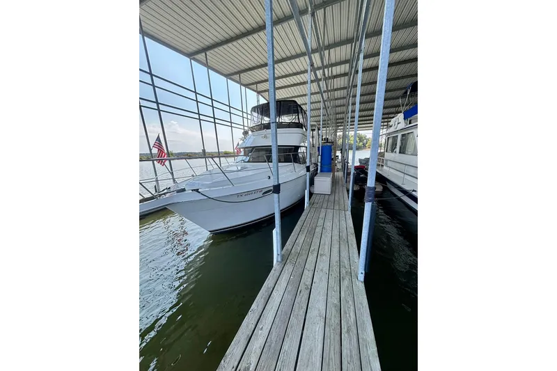 Slide: The Image of 2001 Carver 356 Motor Yacht docked under covered marina with American flag. - 49