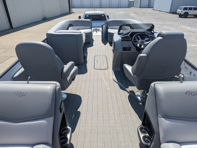 Slide: The Image of 2022 Manitou Encore 25 RF pontoon boat interior with gray seating and steering console. - 15
