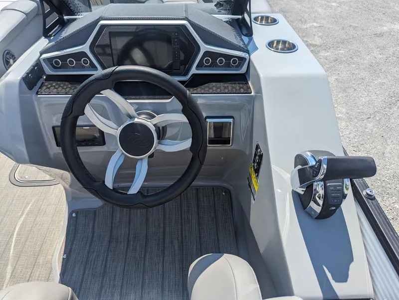 Slide: The Image of 2022 Manitou Encore 25 RF boat dashboard with steering wheel and controls. - 19