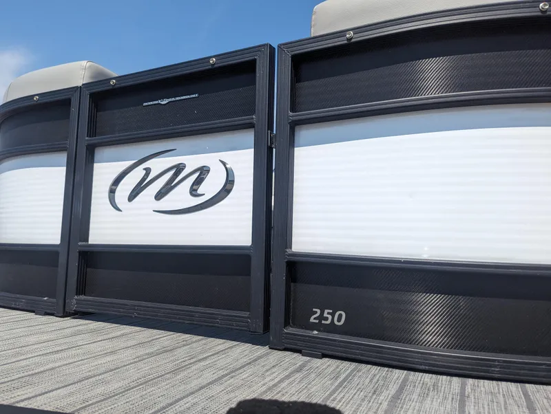 Slide: The Image of 2022 Manitou Encore 25 RF pontoon boat with sleek design and "M" logo. - 31