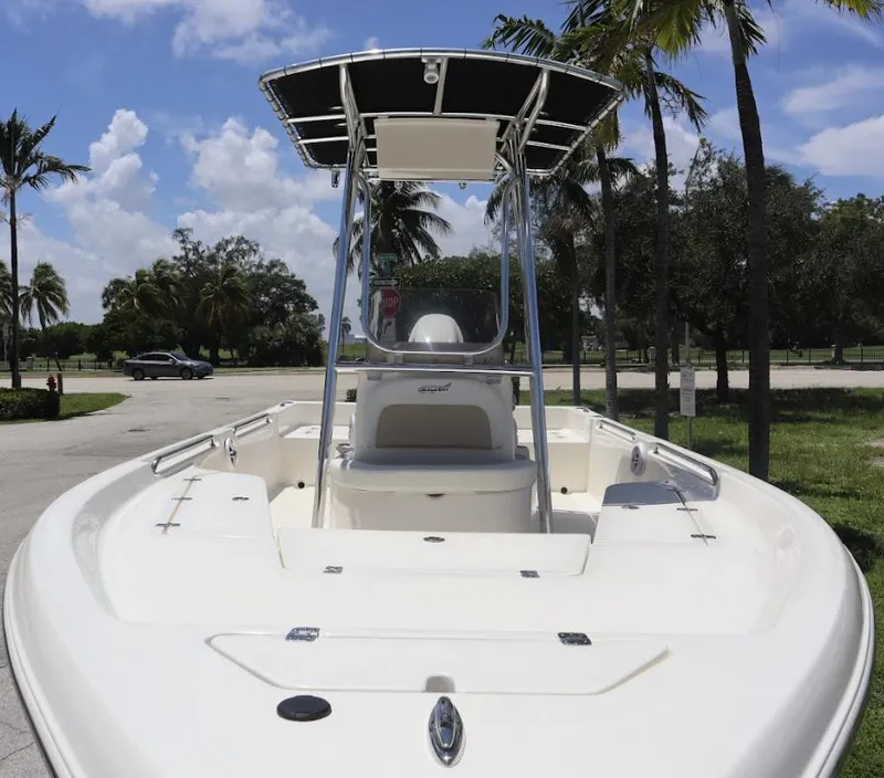 Slide: The Image of 2025 Bulls Bay 2200 boat with T-top, parked under palm trees. - 4