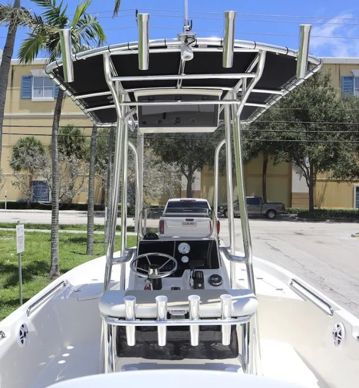 Slide: The Image of 2025 Bulls Bay 2200 boat with T-top and rod holders, parked outdoors. - 5