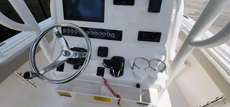Slide: The Image of 2025 Key West 239 FS boat dashboard with steering wheel and controls. - 11