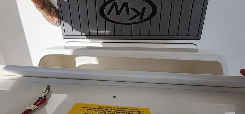 Slide: The Image of Key West 239 FS boat interior detail, featuring storage compartment and KW logo, 2025 model. - 13