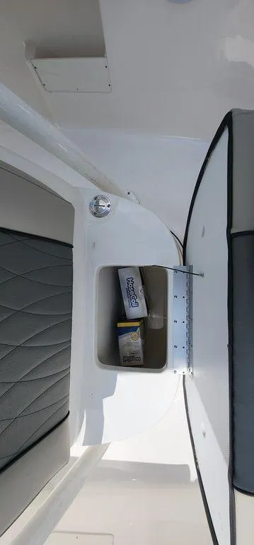 Slide: The Image of 2025 Key West 239 FS boat interior storage compartment with cushioned seating. - 16