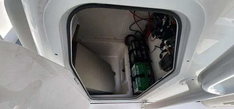 Slide: The Image of Key West 239 FS 2025 boat storage compartment with batteries and wiring. - 25