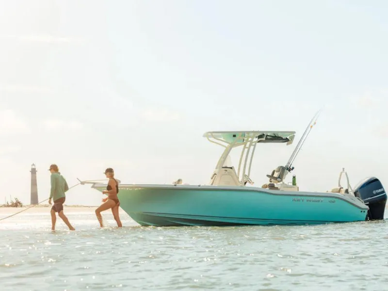 Slide: The Image of 2025 Key West 239 FS boat in shallow water with two people nearby. - 3