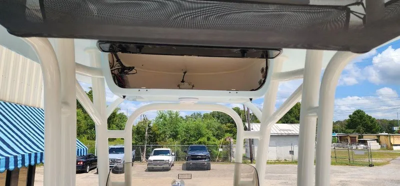 Slide: The Image of 2025 Key West 239 FS boat interior with T-top and parked cars in the background. - 38