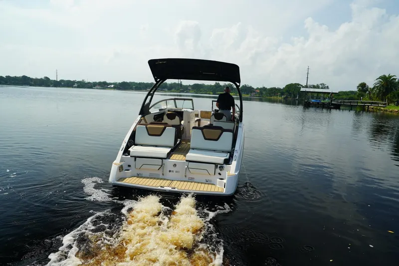 Slide: The Image of 2021 Yamaha Boats 252SE cruising on a serene lake. - 1