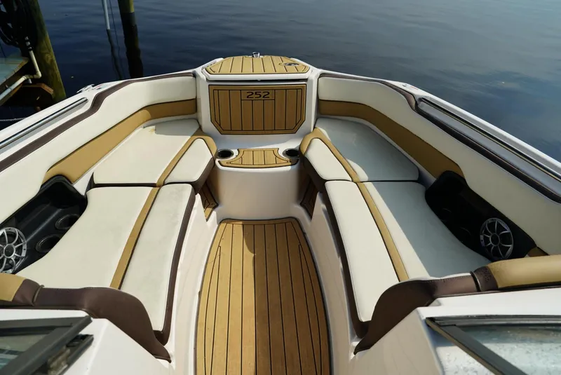 Slide: The Image of 2021 Yamaha Boats 252SE interior with luxurious seating and wood accents. - 16