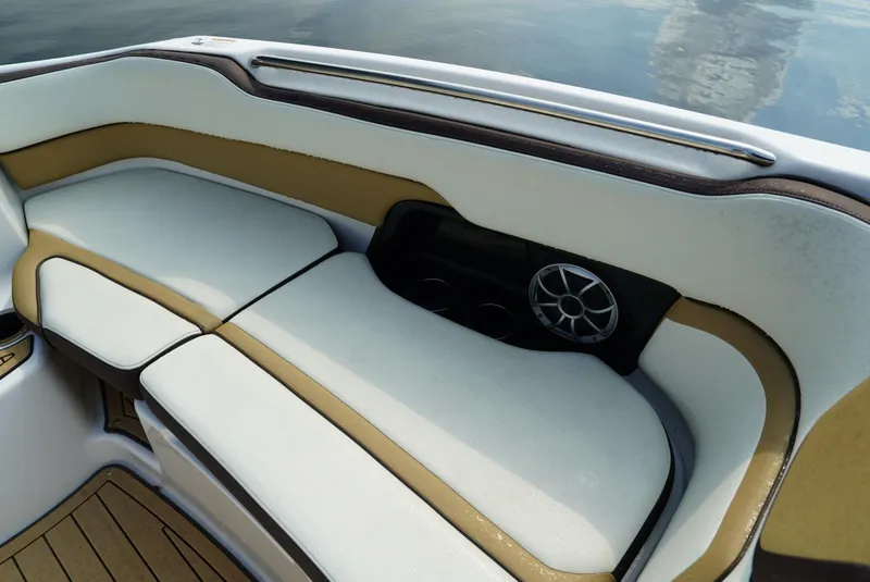 Slide: The Image of 2021 Yamaha Boats 252SE interior seating with speaker, featuring white and tan upholstery. - 17