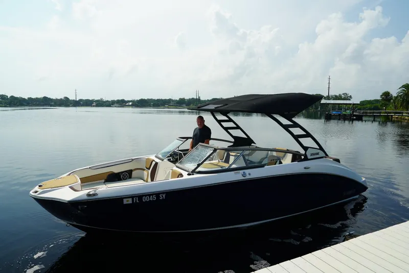 Slide: The Image of 2021 Yamaha Boats 252SE on calm water, featuring sleek design and spacious interior. - 2