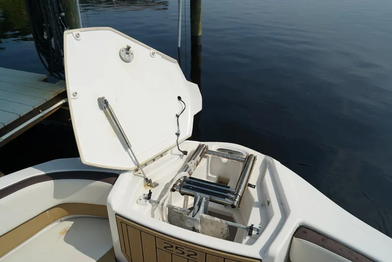 Slide: The Image of Yamaha Boats 252SE 2021 model with open storage compartment by the water. - 23