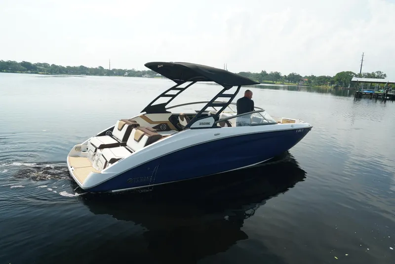 Slide: The Image of 2021 Yamaha Boats 252SE on calm water, featuring sleek design and spacious seating. - 3